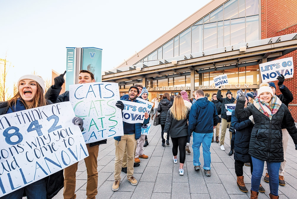 Large crowd of students holding signs and cheering outside of Finneran Pavilion.