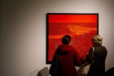 Two people looking at an art piece