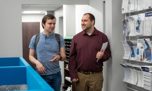 Student speaking to a staff member as they both are walking through the Career Center.