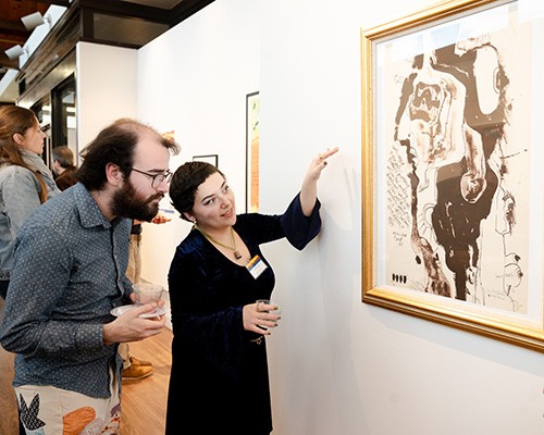 Patrons look at a piece at the exhibit, "Abstract Activism: Sam Maitin's Philadelphia." Patrons look at a piece at the exhibit, "Abstract Activism: Sam Maitin's Philadelphia."