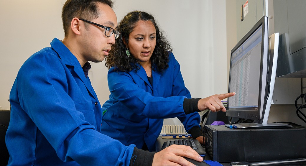 A graduate student and faculty advisor analyze data in an environmental science lab.