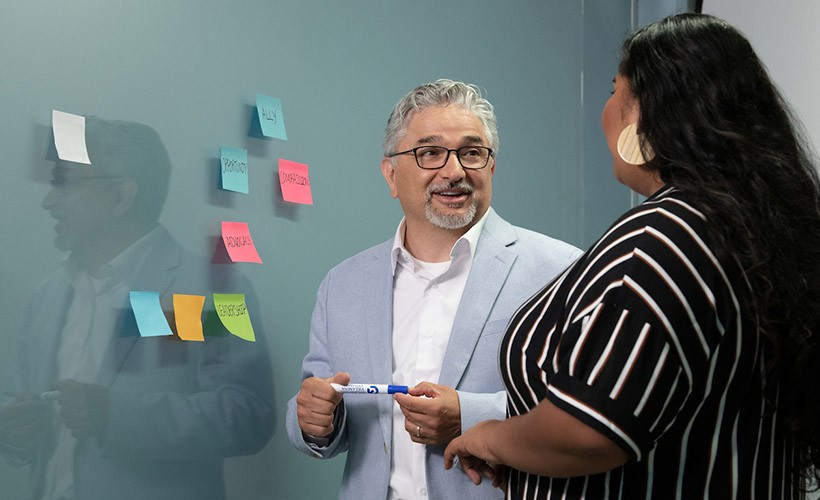 UNITAS: INCLUSIVE EDUCATION Edward Fierros, PhD, associate dean for UNITAS: Inclusive Education, talks with a student.