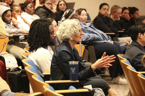A woman gesticulating in an audience