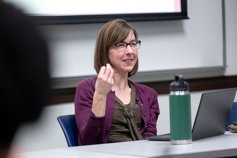 female-professor-speaking-sitting Female professor speaking