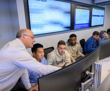 Professor showing students info on a computer screen