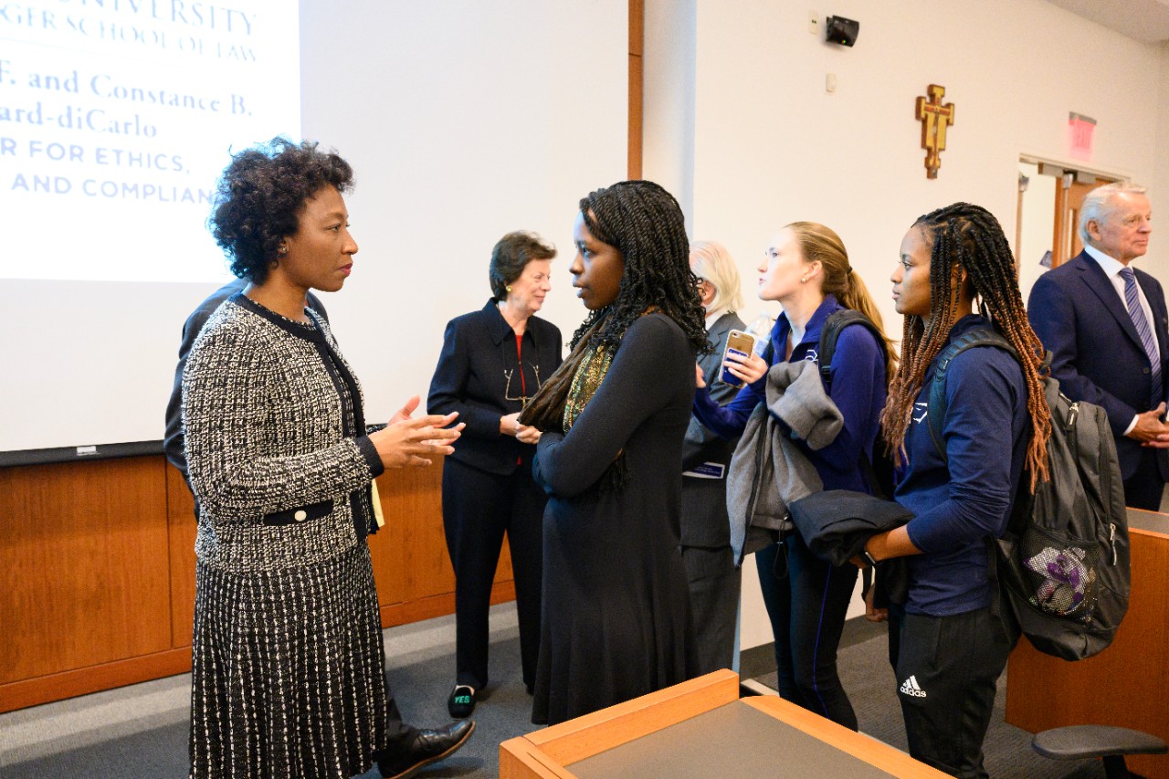 Precious Gittens, Senior Director of Compliance Investigations at Fresenius Medical Care North America, discusses compliance with students after a lecture.