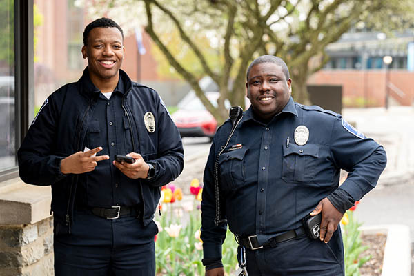 Two officers in uniform smiling at the camera