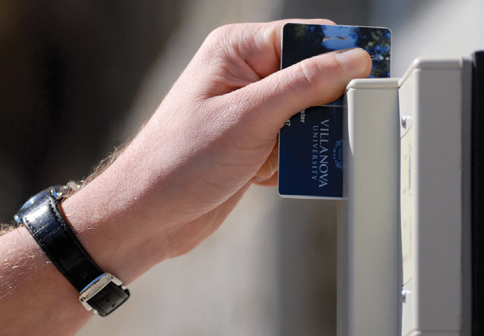 A hand swiping a wildcard for access into a building