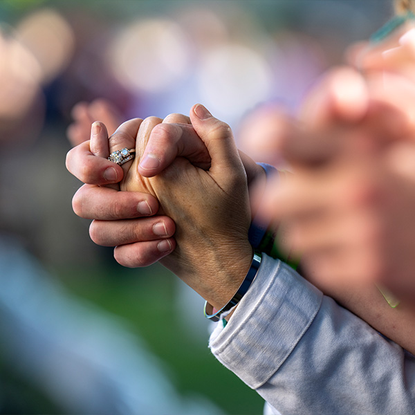Close-up shot of two people holding hands.