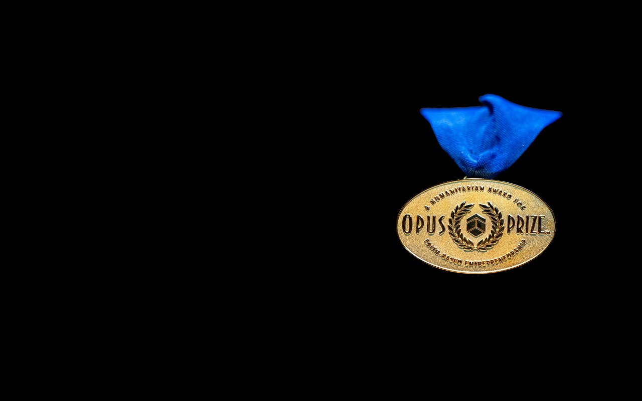The gold Opus Prize medal hangs on a blue ribbon