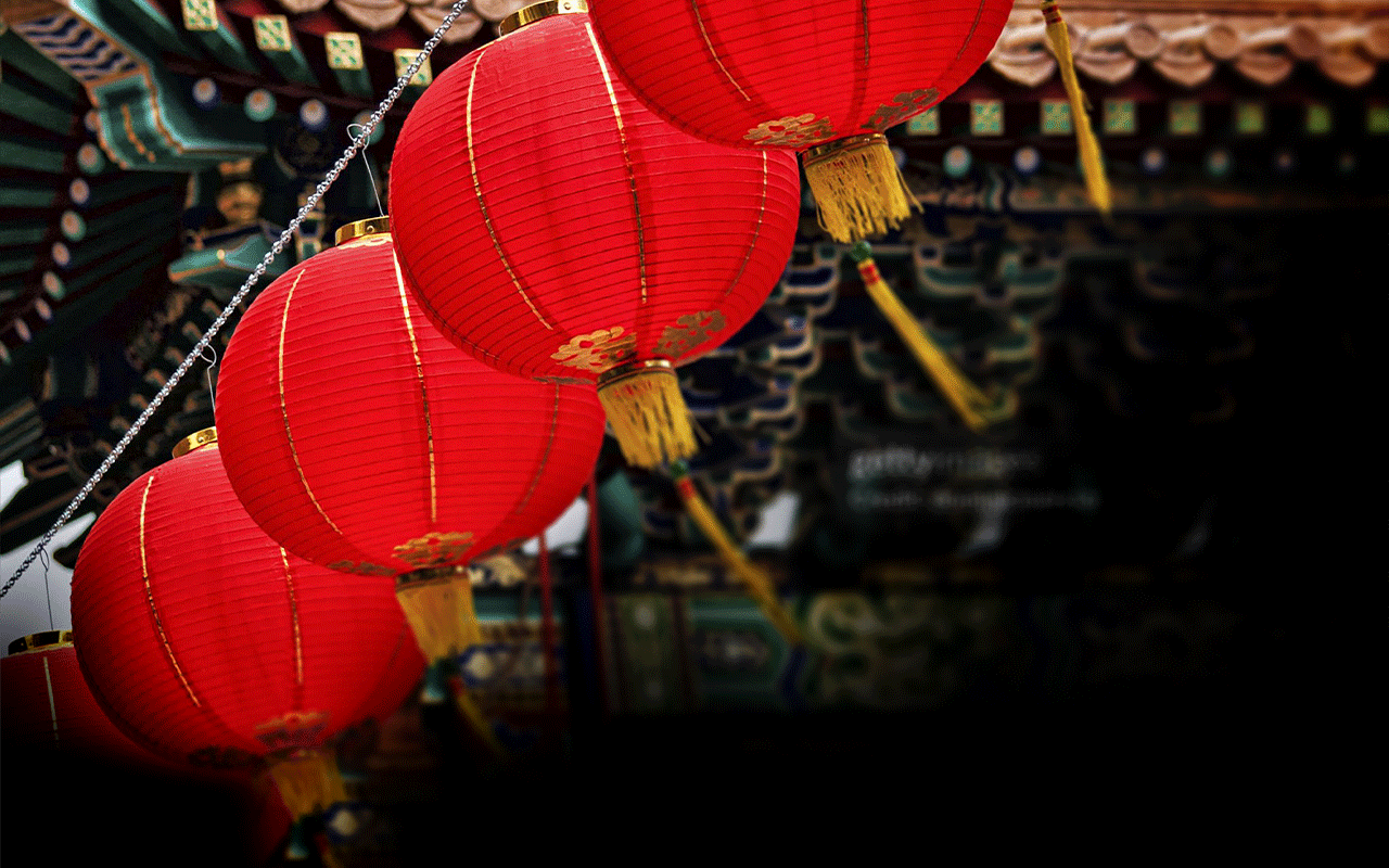 Four Chinese-style red lanterns hanging from a wire